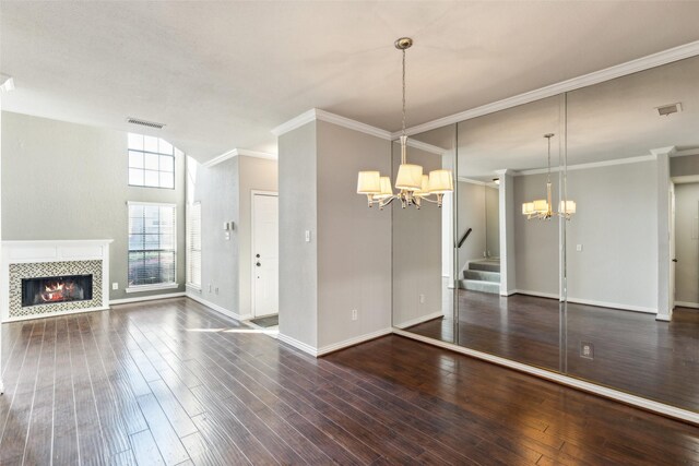 14333 Preston Rd Unit 1103, Dallas, TX 75254 - unfurnished living room with a chandelier, hardwood / wood-style floors, a tiled fireplace, baseboards, and crown molding