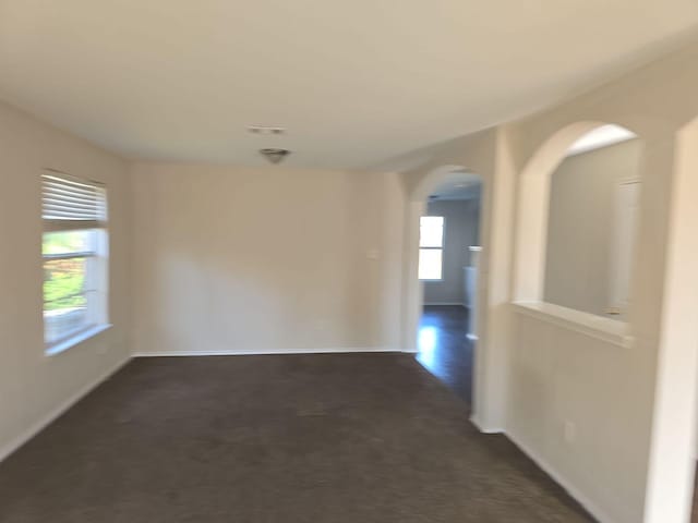 8313 French Quarter Ln, Fort Worth, TX 76123 - unfurnished room featuring arched walkways, baseboards, and dark colored carpet
