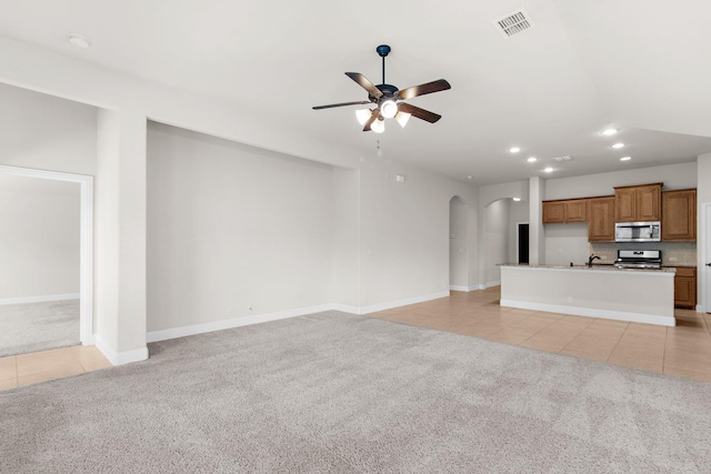 1105 Pigeon Hawk Dr, Little Elm, TX 75068 - unfurnished living room featuring light colored carpet, arched walkways, light tile patterned floors, and recessed lighting