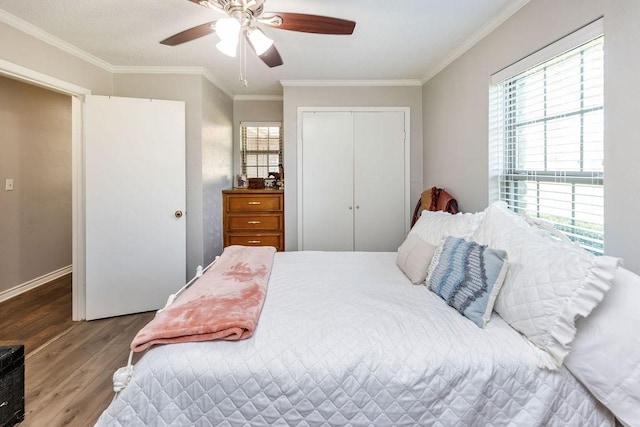 9216 Fm 195, Paris, TX 75462 - bedroom featuring wood finished floors, a closet, ornamental molding, ceiling fan, and baseboards