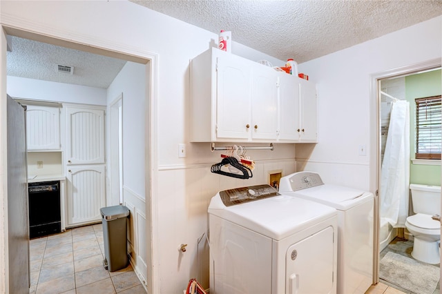 5808 Arbor Valley Dr, Arlington, TX 76016 - washroom with a textured ceiling, washer and dryer, cabinet space, a wainscoted wall, and light tile patterned flooring