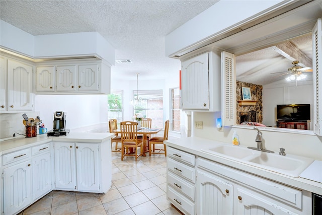 5808 Arbor Valley Dr, Arlington, TX 76016 - kitchen featuring a sink, a ceiling fan, a textured ceiling, light tile patterned floors, and light countertops