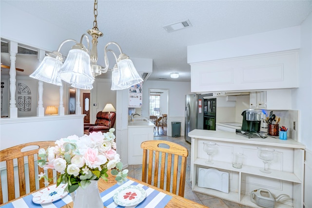 5808 Arbor Valley Dr, Arlington, TX 76016 - dining room with light tile patterned floors, a chandelier, and a textured ceiling