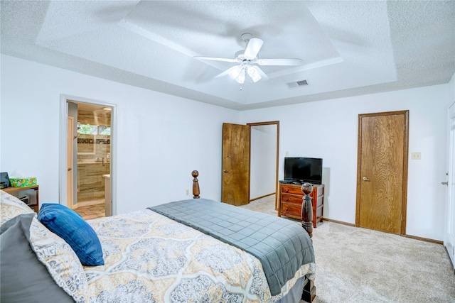 5808 Arbor Valley Dr, Arlington, TX 76016 - bedroom featuring a textured ceiling, a tray ceiling, light colored carpet, connected bathroom, and ceiling fan