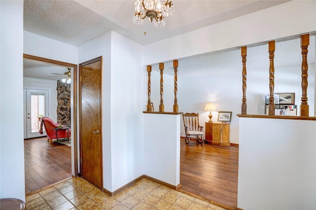 5808 Arbor Valley Dr, Arlington, TX 76016 - corridor featuring a textured ceiling, baseboards, a chandelier, and wood finished floors