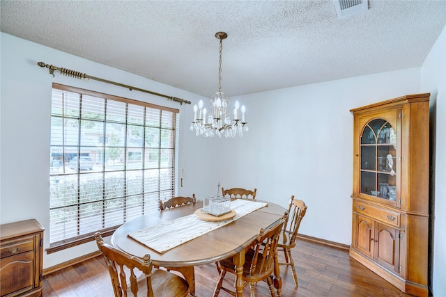 5808 Arbor Valley Dr, Arlington, TX 76016 - dining space featuring a chandelier, a textured ceiling, hardwood / wood-style flooring, and baseboards