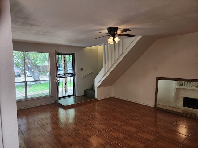 2614 Santa Barbara Dr, Grand Prairie, TX 75052 - unfurnished living room with stairs, healthy amount of natural light, a ceiling fan, and a fireplace