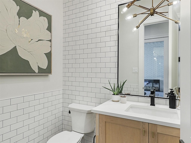 2015 Honey Ln, Celina, TX 75009 - bathroom featuring tile walls, toilet, vanity, and a chandelier