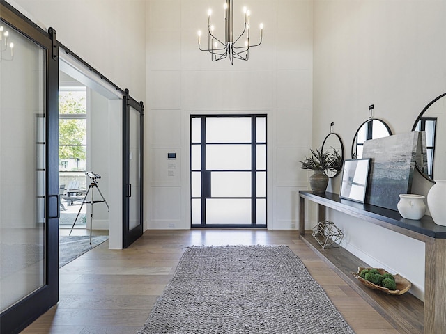 2015 Honey Ln, Celina, TX 75009 - foyer entrance with a barn door, a towering ceiling, a chandelier, and wood finished floors