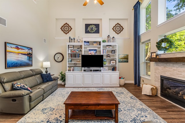 4 Raintree Ct, Mansfield, TX 76063 - living area featuring a towering ceiling, a ceiling fan, wood finished floors, baseboards, and a fireplace