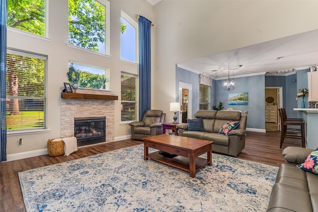 4 Raintree Ct, Mansfield, TX 76063 - living room with crown molding, a chandelier, baseboards, wood finished floors, and a stone fireplace