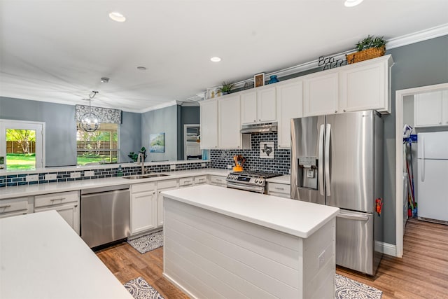 4 Raintree Ct, Mansfield, TX 76063 - kitchen with appliances with stainless steel finishes, a sink, decorative backsplash, light wood finished floors, and ornamental molding