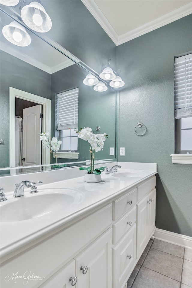 full bath with ornamental molding, tile patterned flooring, double vanity, a textured wall, and baseboards