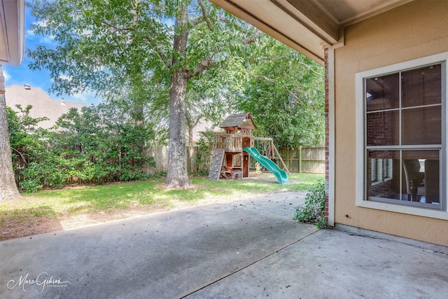 view of patio featuring a playground and fence
