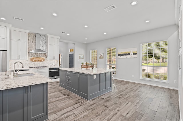 1701 Travis Ct, Allen, TX 75002 - kitchen featuring gray cabinets, wall chimney exhaust hood, a sink, stainless steel oven, and a kitchen island