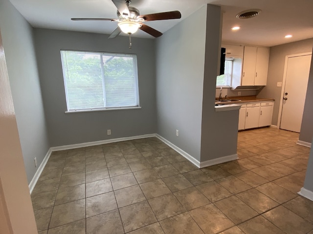 4233 Ridgecrest Cir, Lake Worth, TX 76135 - kitchen with tile patterned floors, a ceiling fan, white cabinets, a sink, and baseboards