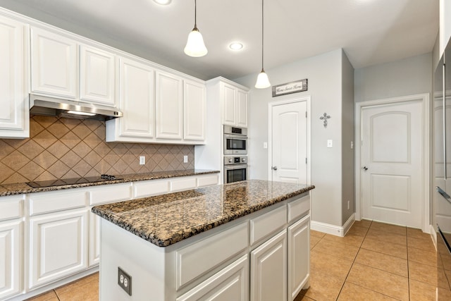 1250 Amistad Dr, Prosper, TX 75078 - kitchen featuring under cabinet range hood, black electric cooktop, backsplash, double oven, and dark stone counters