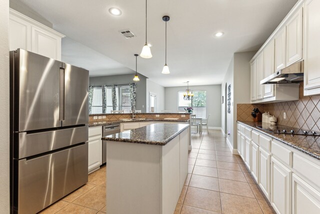 1250 Amistad Dr, Prosper, TX 75078 - kitchen with stainless steel appliances, under cabinet range hood, backsplash, light tile patterned floors, and recessed lighting