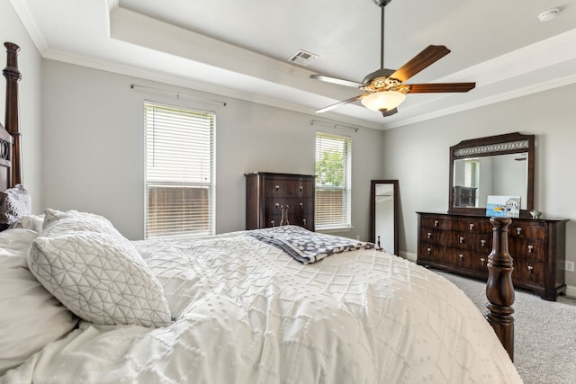 carpeted bedroom featuring a raised ceiling, crown molding, baseboards, and ceiling fan