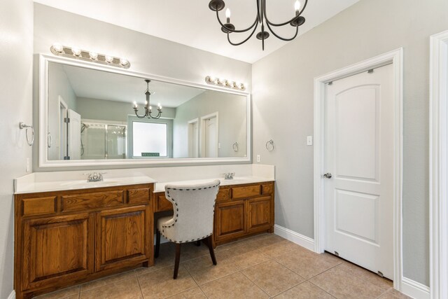 1250 Amistad Dr, Prosper, TX 75078 - bathroom featuring a chandelier, double vanity, tile patterned floors, a shower with shower door, and baseboards