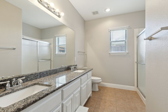 full bathroom with plenty of natural light, a stall shower, toilet, and double vanity
