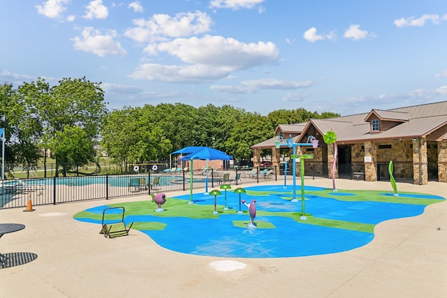 community jungle gym featuring fence and a community pool