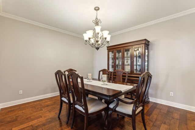 dining space featuring a chandelier, dark wood-type flooring, ornamental molding, and baseboards