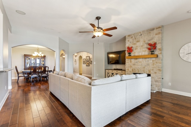 living room featuring arched walkways, dark wood-type flooring, a ceiling fan, and a chandelier