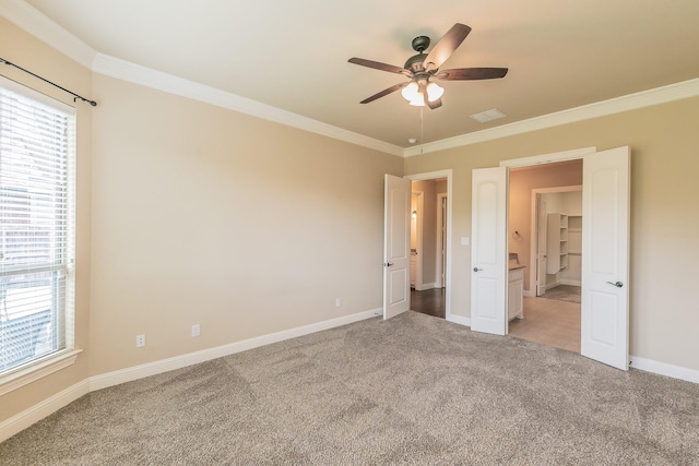 unfurnished bedroom with ornamental molding, light colored carpet, multiple windows, baseboards, and ceiling fan