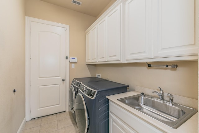 laundry room featuring cabinet space, independent washer and dryer, light tile patterned floors, and baseboards