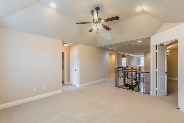 empty room featuring lofted ceiling, light colored carpet, baseboards, a ceiling fan, and recessed lighting