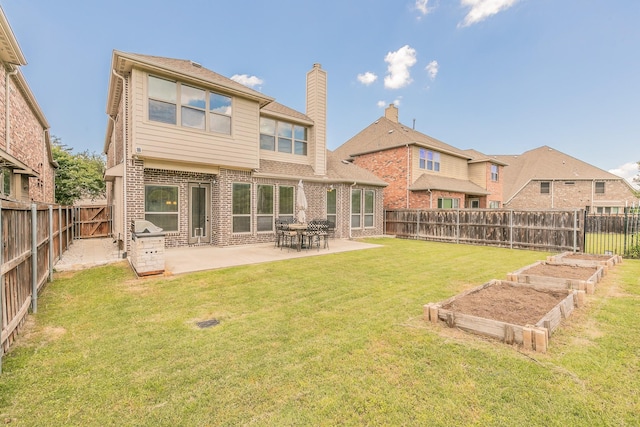 rear view of property featuring a garden, brick siding, a patio, and a chimney
