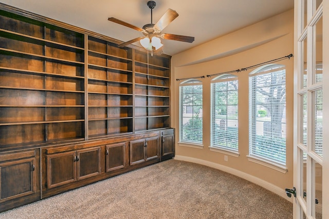 unfurnished office featuring light carpet and a ceiling fan