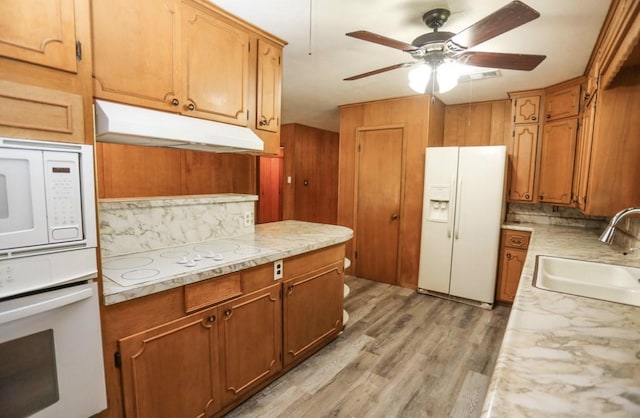 405 W Neely Ave, Comanche, TX 76442 - kitchen featuring white appliances, under cabinet range hood, a sink, backsplash, and light wood-style flooring