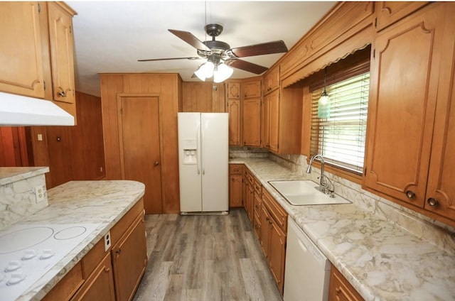 405 W Neely Ave, Comanche, TX 76442 - kitchen featuring white appliances, a sink, brown cabinets, a ceiling fan, and light wood-style flooring