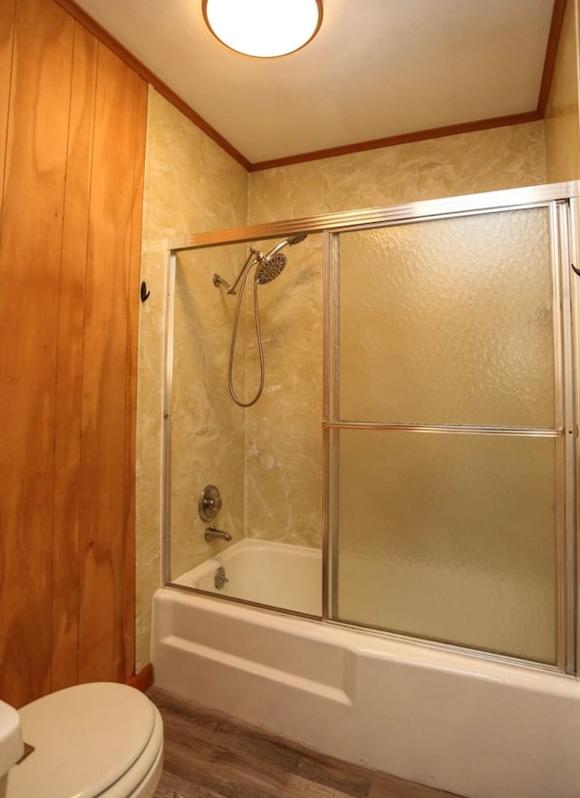 405 W Neely Ave, Comanche, TX 76442 - bathroom featuring wood finished floors, toilet, ornamental molding, and combined bath / shower with glass door