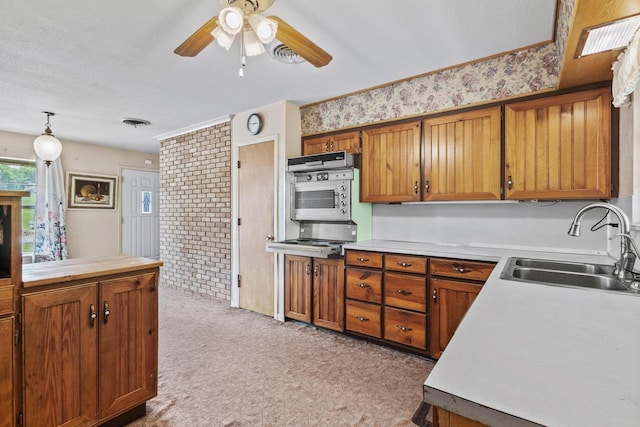 531 Eisenhower Rd, Denison, TX 75020 - kitchen featuring a sink, light carpet, brown cabinets, ceiling fan, and light countertops