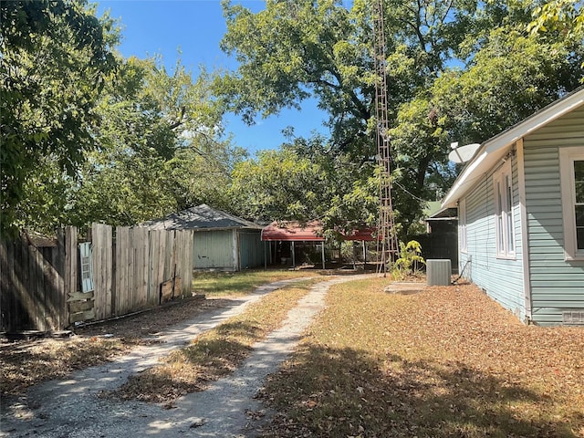 118 S 31st St, Corsicana, TX 75110 - view of yard with central AC, dirt driveway, fence, an outbuilding, and a storage shed