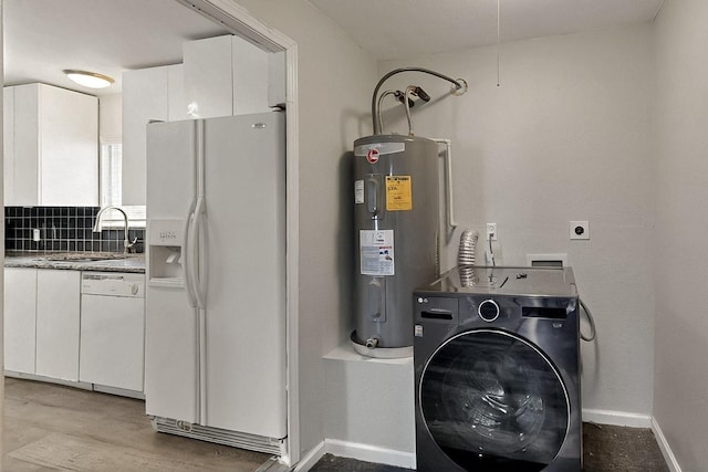 1508 E Dellis St, Kaufman, TX 75142 - washroom with washer / clothes dryer, electric water heater, baseboards, and light wood-style floors