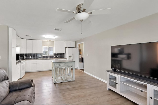 1508 E Dellis St, Kaufman, TX 75142 - living room with a ceiling fan, light wood-style flooring, and baseboards