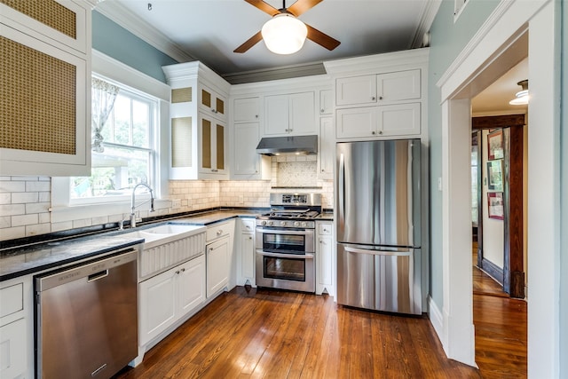 5020 Junius St, Dallas, TX 75214 - kitchen with stainless steel appliances, under cabinet range hood, dark countertops, dark wood-style flooring, and glass insert cabinets