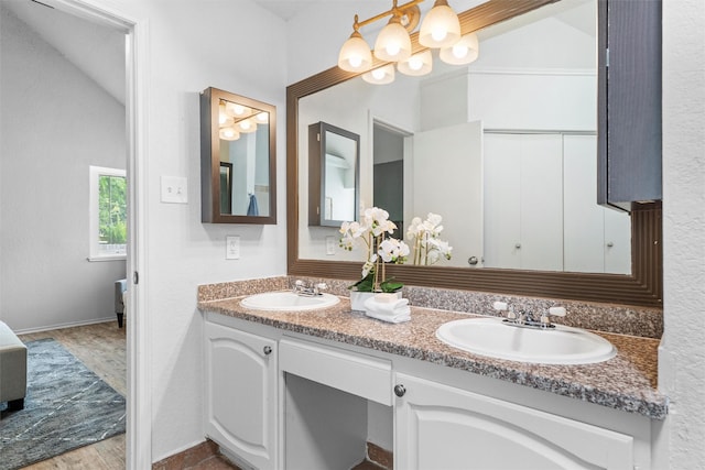 1115 Cherrytree Dr, Arlington, TX 76001 - bathroom with a chandelier, double vanity, and baseboards