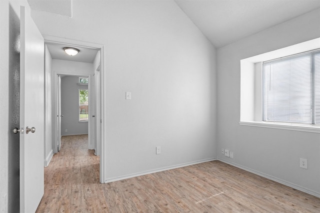 1115 Cherrytree Dr, Arlington, TX 76001 - empty room with light wood finished floors, vaulted ceiling, and baseboards