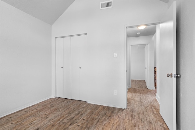 1115 Cherrytree Dr, Arlington, TX 76001 - unfurnished bedroom featuring vaulted ceiling, wood finished floors, a closet, and baseboards