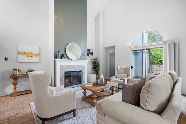 1115 Cherrytree Dr, Arlington, TX 76001 - living room with a high ceiling, a high end fireplace, wood finished floors, and baseboards