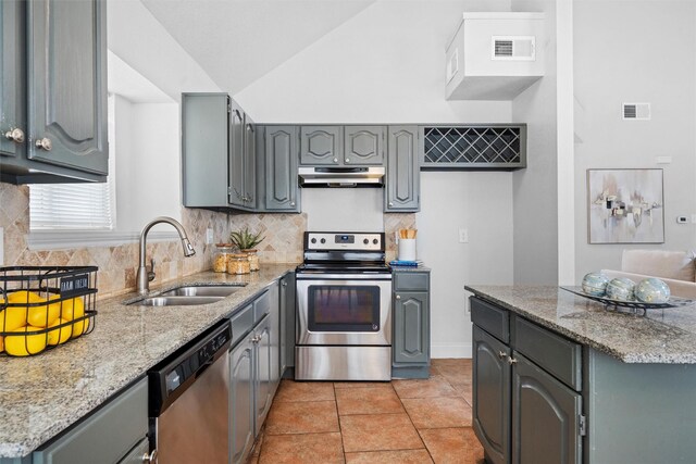 1115 Cherrytree Dr, Arlington, TX 76001 - kitchen with appliances with stainless steel finishes, under cabinet range hood, gray cabinetry, a sink, and backsplash