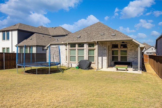 2434 Solomons Pl, Wylie, TX 75098 - rear view of property featuring brick siding, a patio, a trampoline, roof with shingles, and an outdoor living space