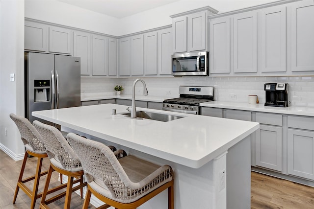 2434 Solomons Pl, Wylie, TX 75098 - kitchen featuring appliances with stainless steel finishes, a sink, decorative backsplash, and a kitchen breakfast bar