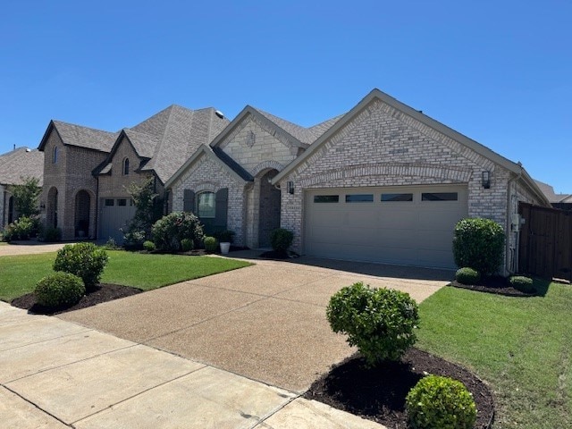 2434 Solomons Pl, Wylie, TX 75098 - french country home with driveway, an attached garage, brick siding, and a front lawn
