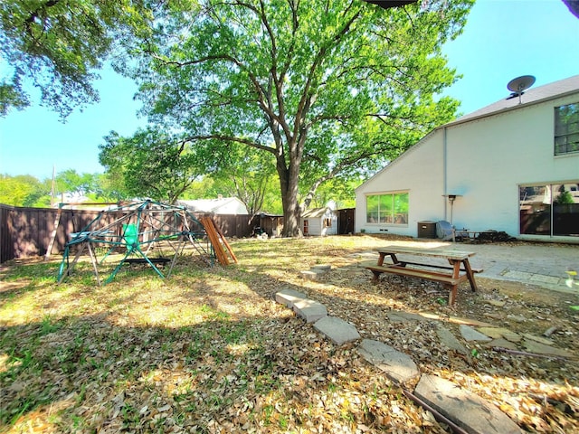 912 Chadwick Dr, Richardson, TX 75080 - fenced backyard featuring a shed, an outbuilding, a playground, and a patio